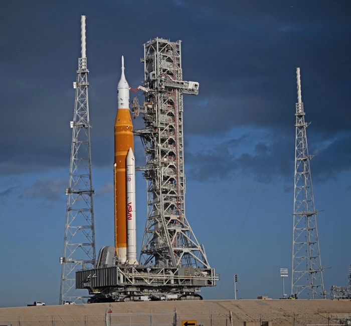 La fusée SLS (Space Launch System) de la NASA et le vaisseau spatial
     Orion, fixés au lanceur mobile, sont vus à leur arrivée sur le pas de tir 39B, le vendredi 20 mars 2026, au Centre spatial Kennedy de
     la NASA en Floride. Crédit : NASA/Joel Kowsky